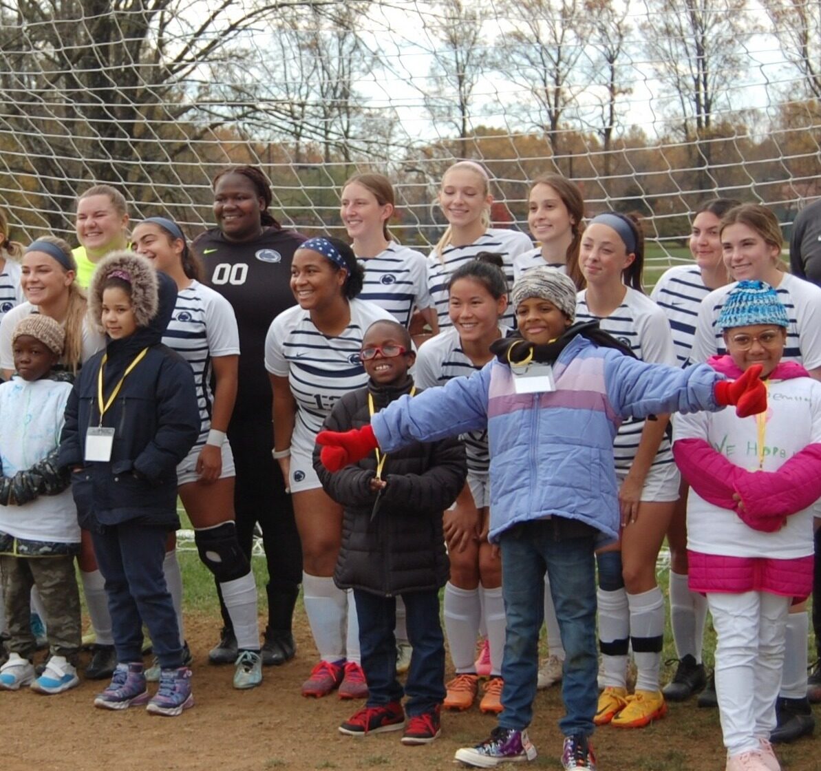 Youth soccer team posing in front of a net.